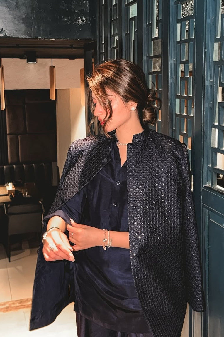 Woman in a stylish outfit standing in a modern interior setting