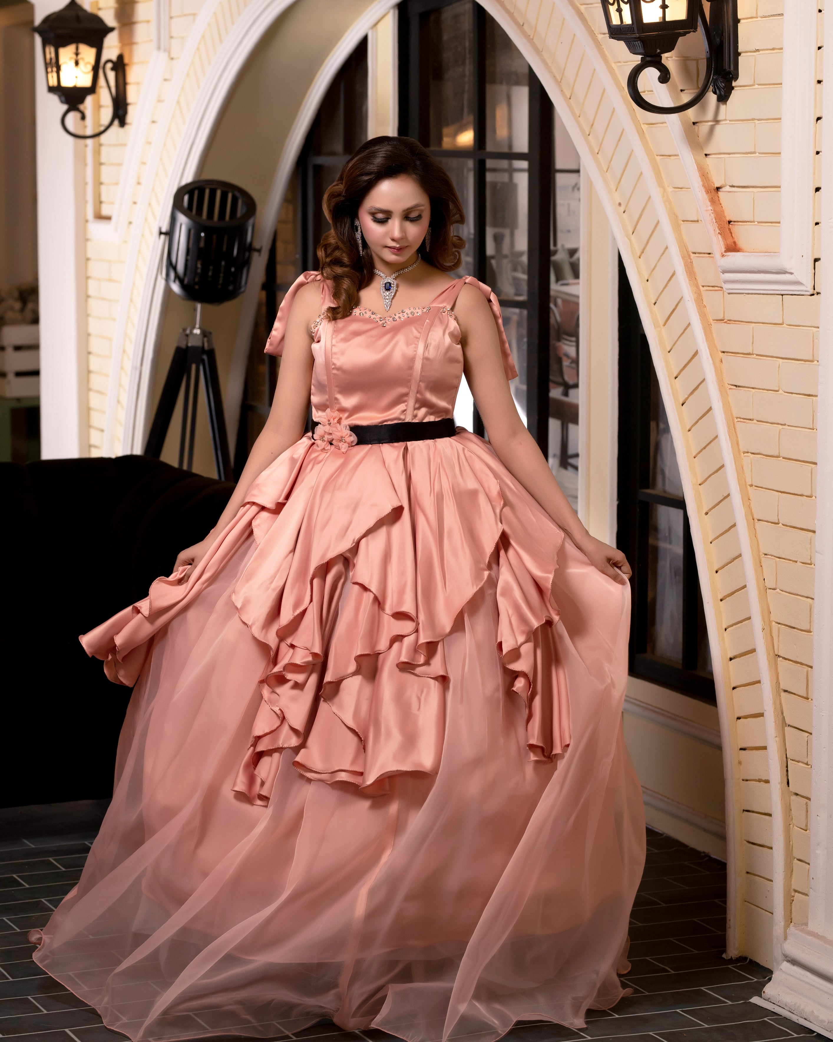 Woman in a pink dress standing in an elegant interior setting