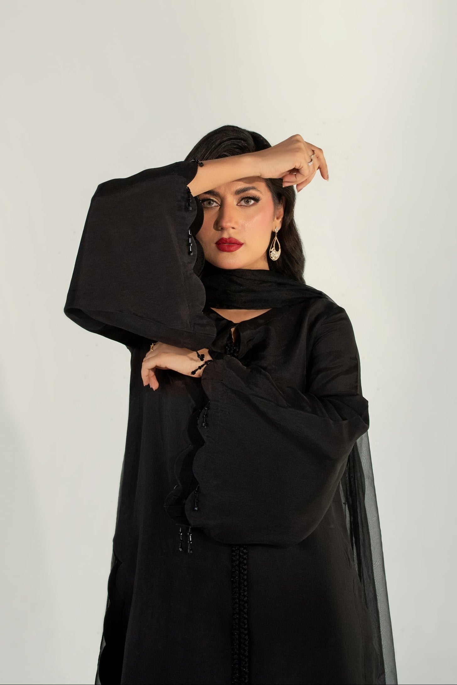 Woman wearing a black outfit against a white background