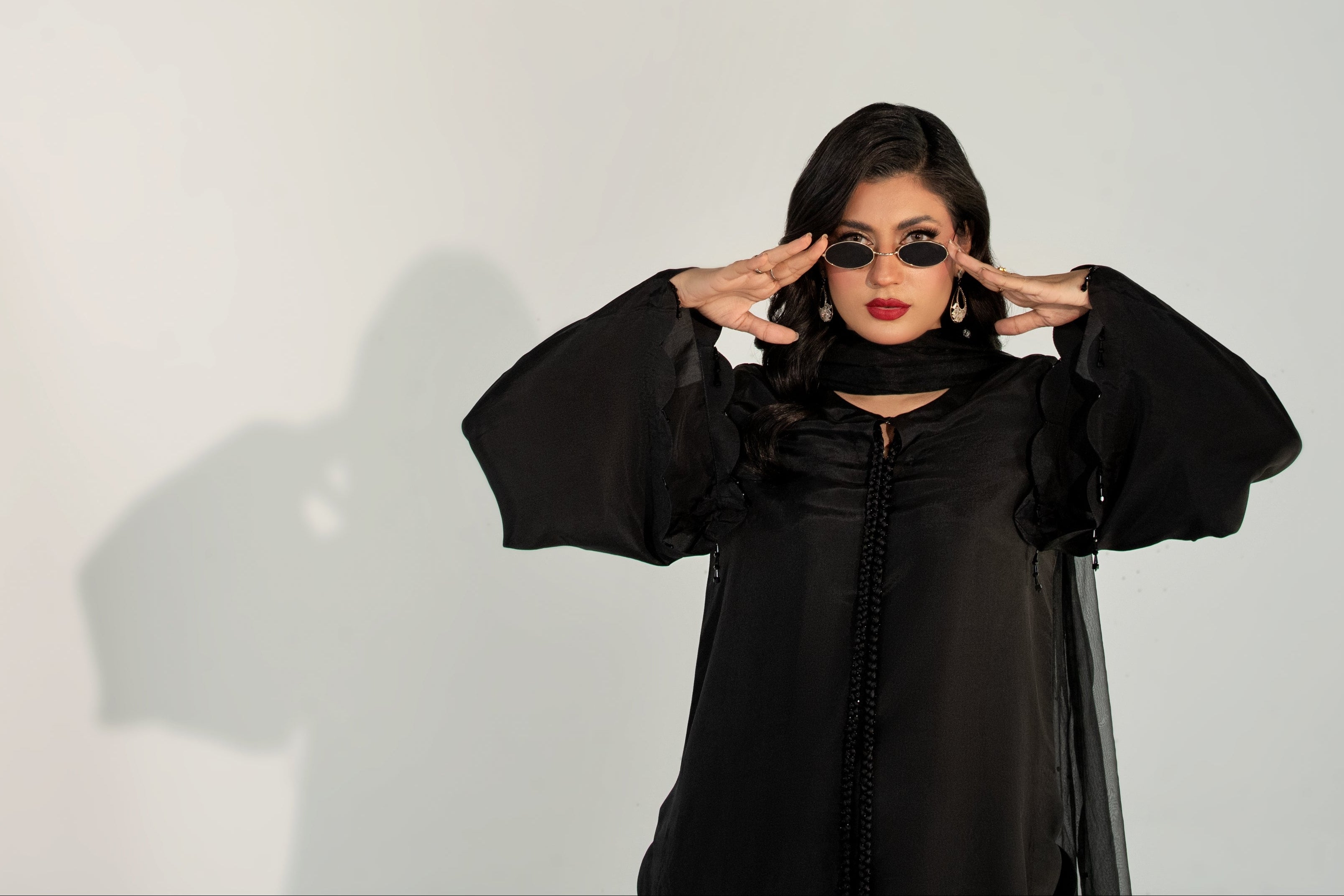 Person wearing a black outfit with a white background