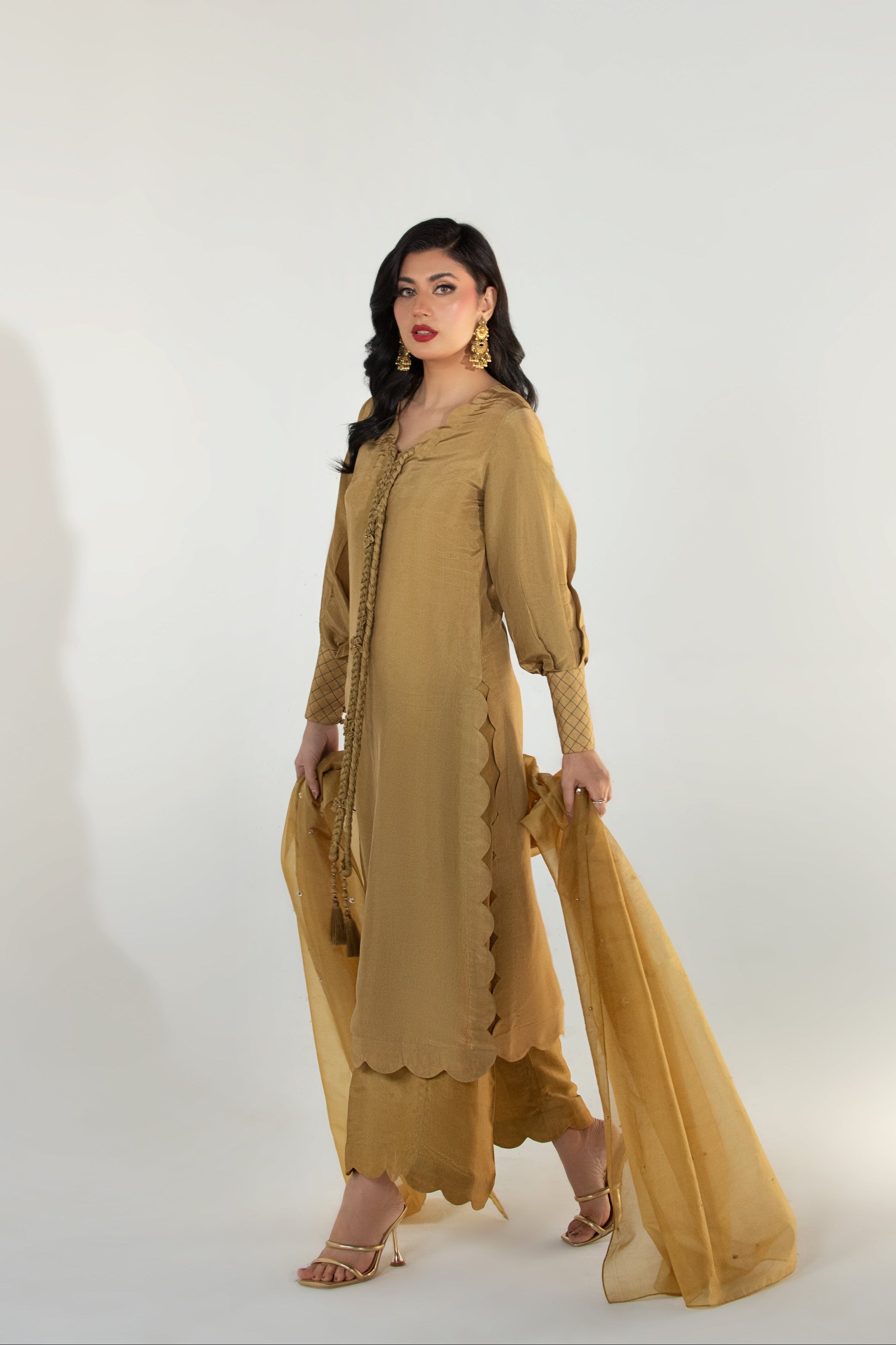 Woman wearing a mustard yellow outfit on a white background