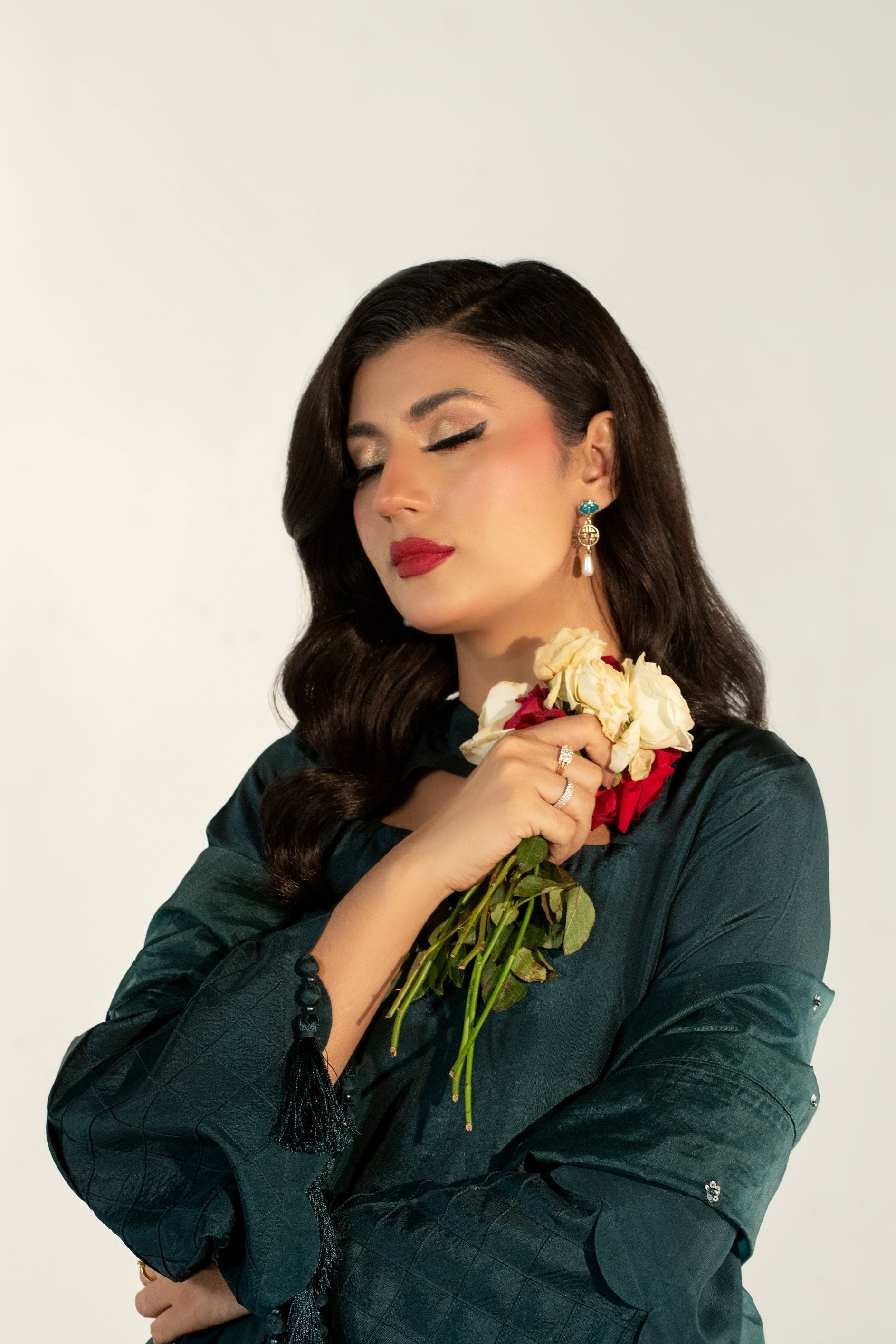 Woman holding a bouquet of flowers against a plain background