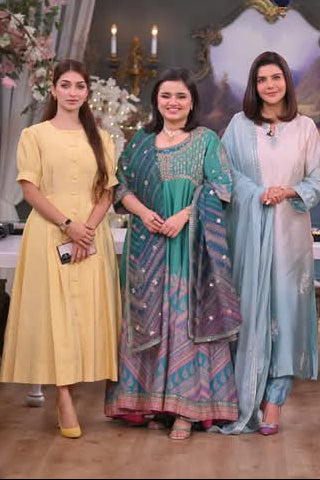 Five women standing together in a decorated room with tables and floral arrangements.