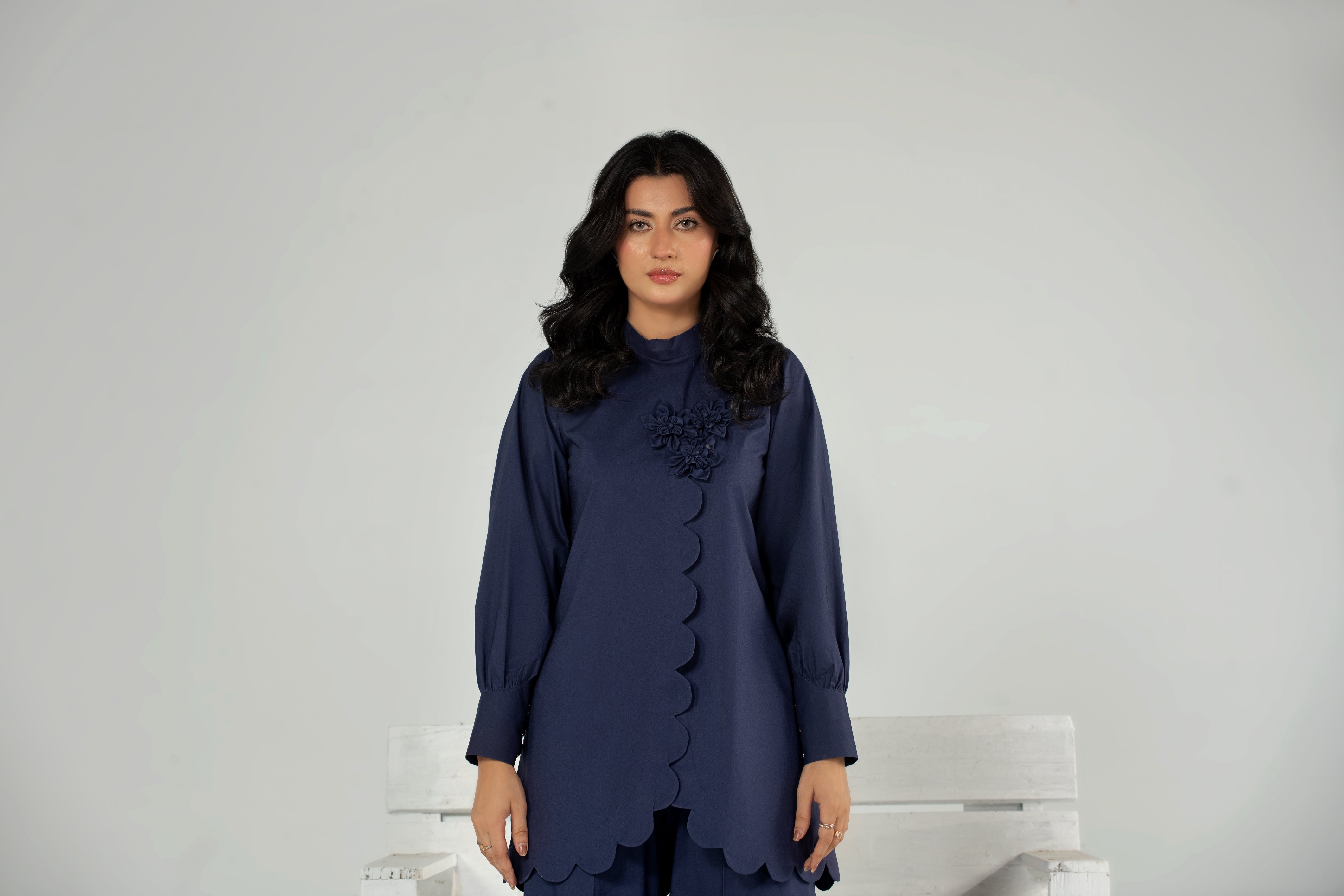 Woman wearing a dark blue dress with a white background