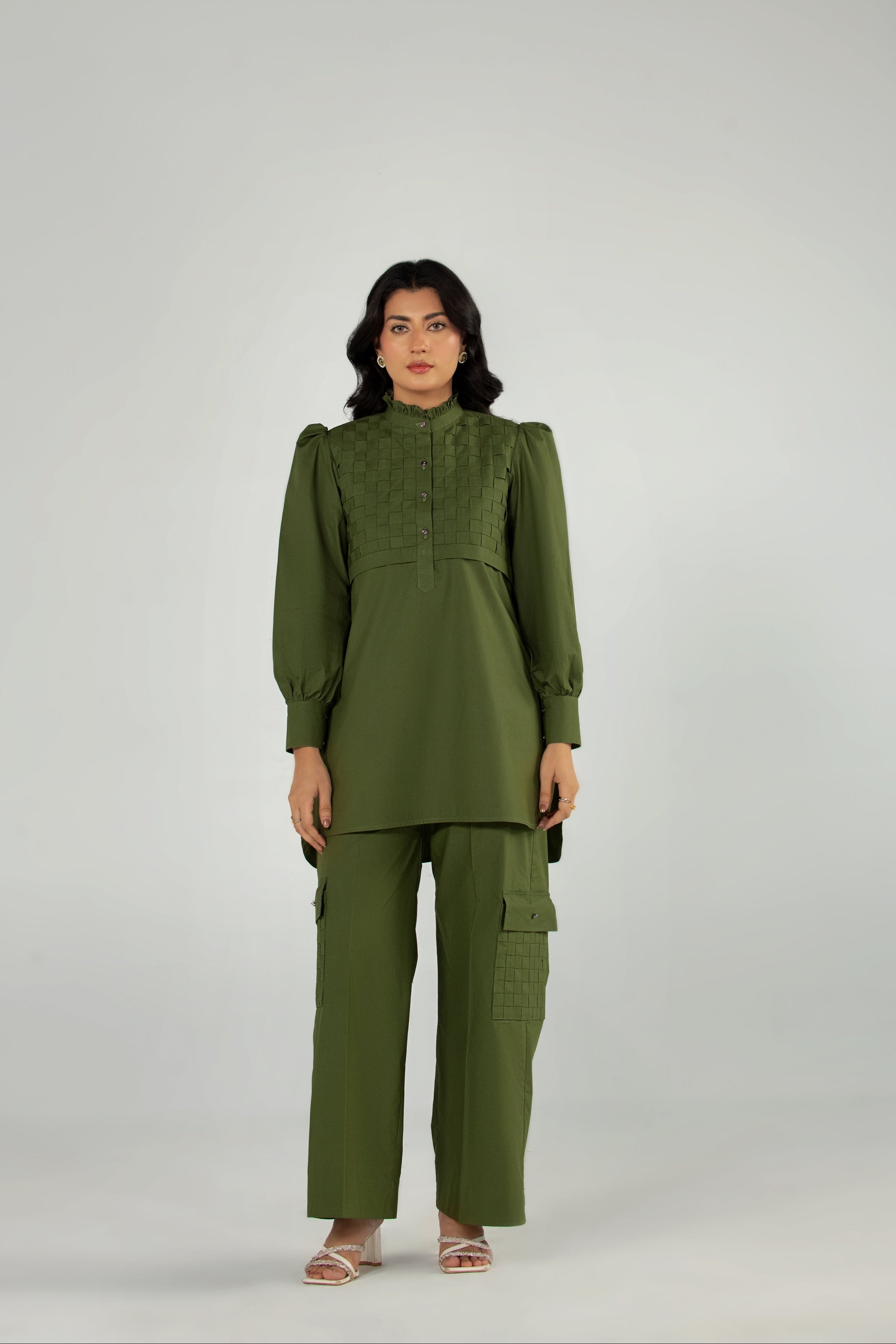 Woman wearing a green outfit on a gray background