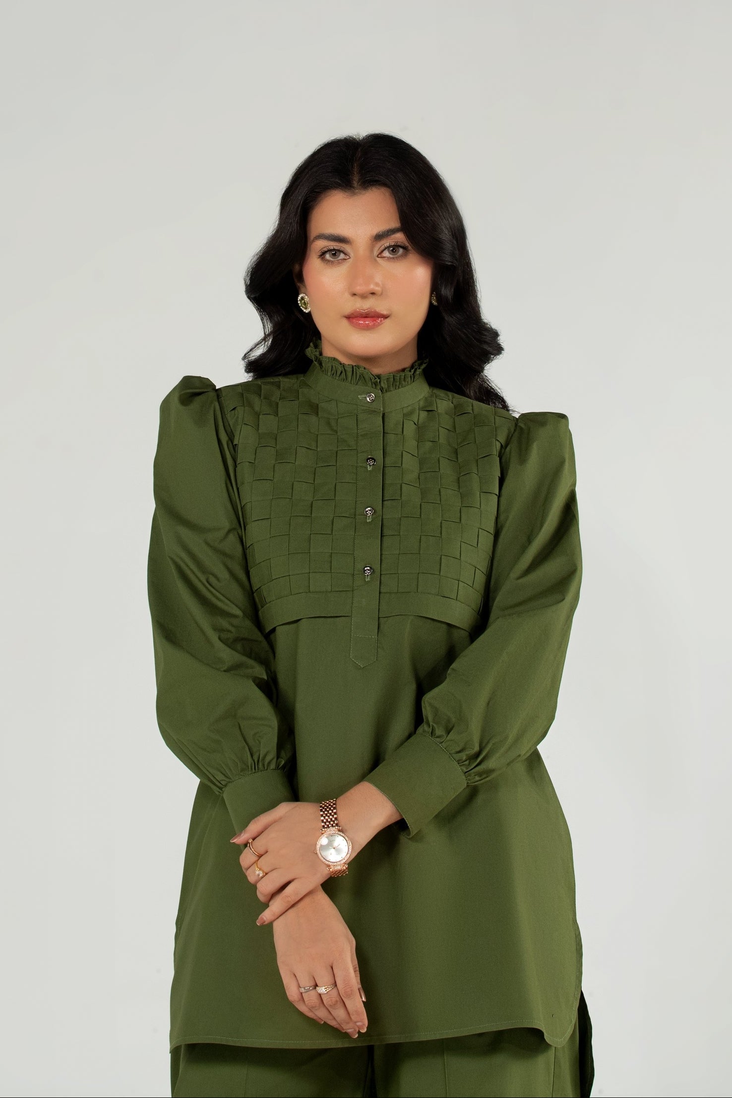 Woman wearing a green outfit against a plain background