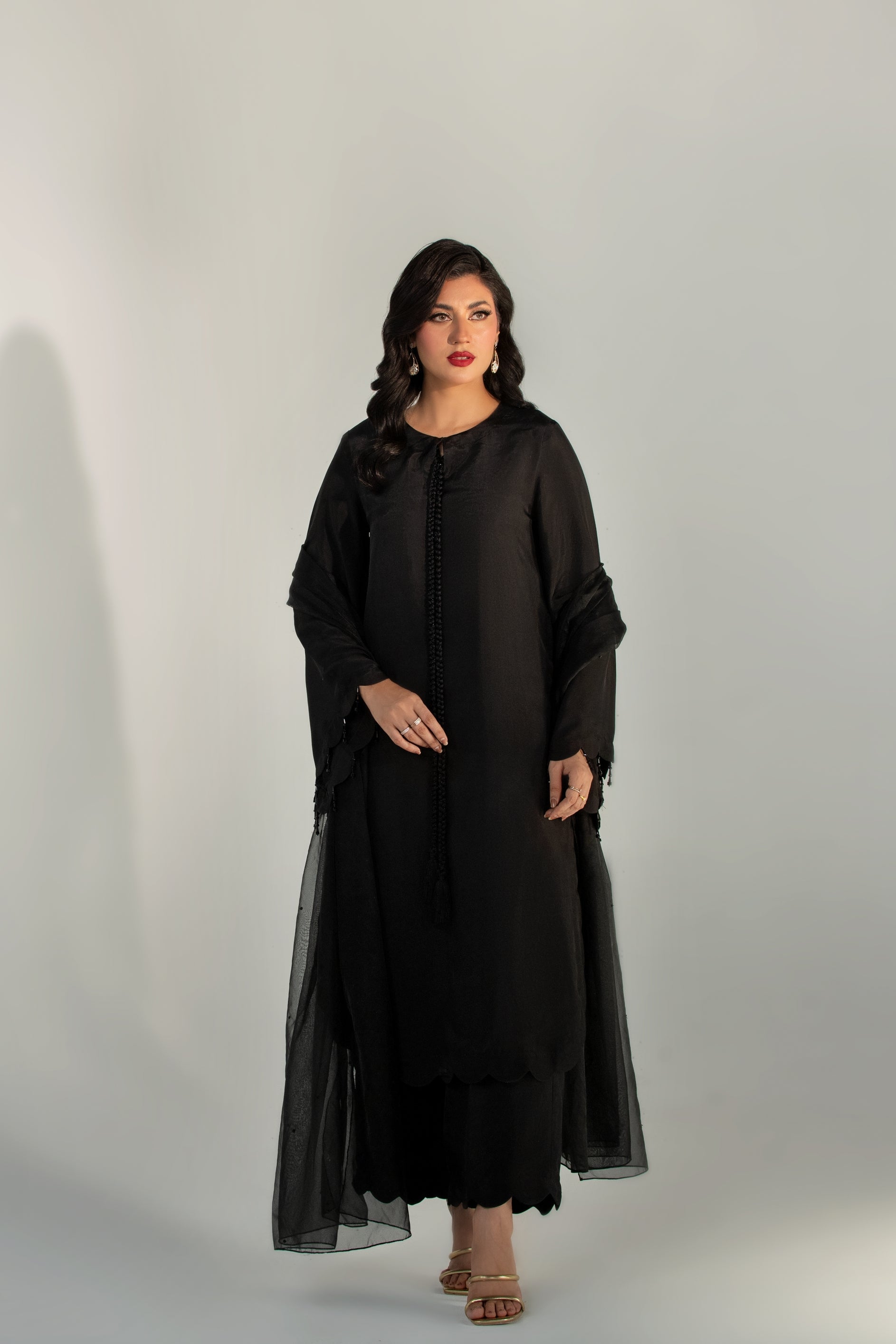 Woman wearing a black dress against a white background