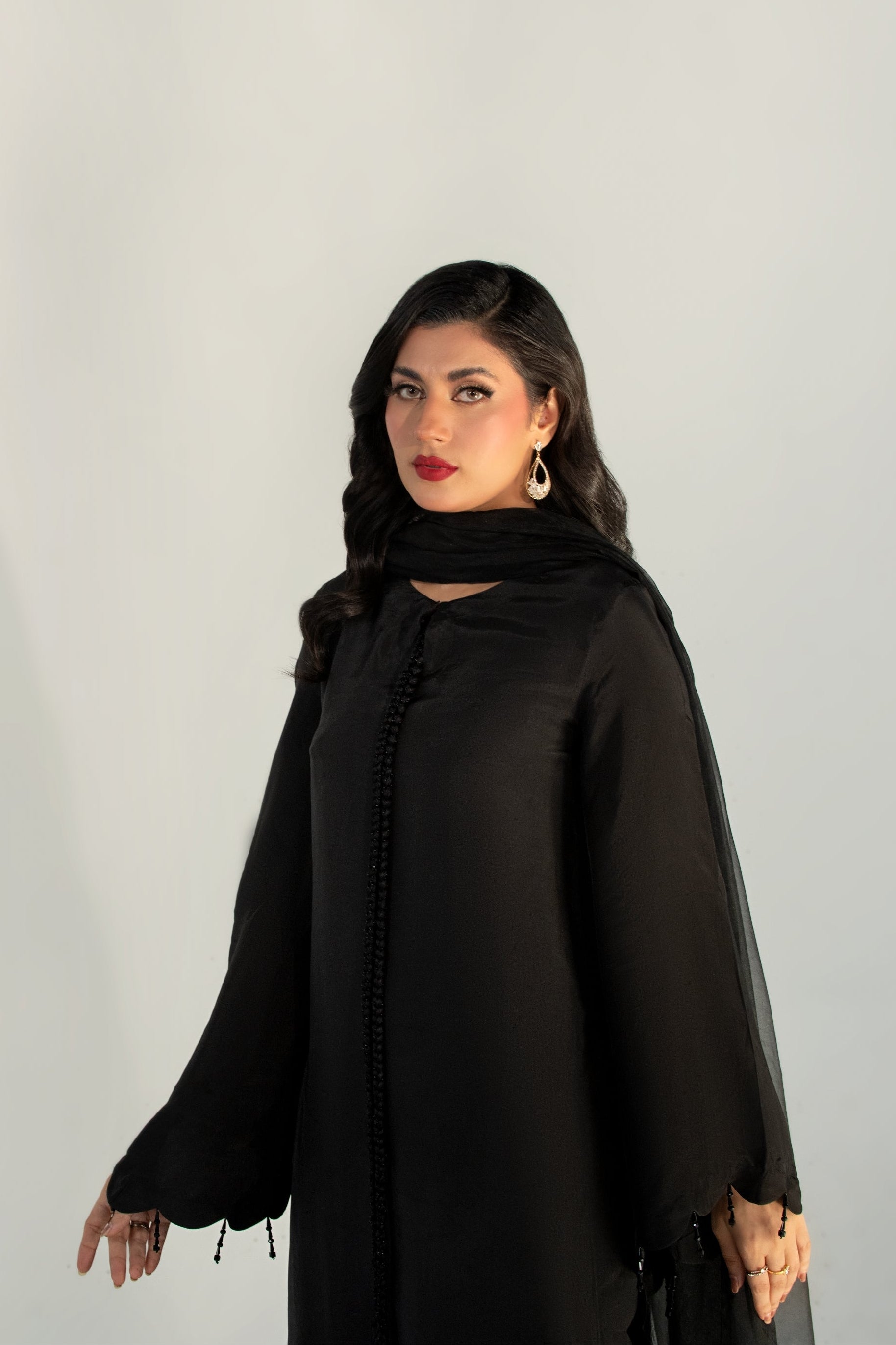 Woman wearing a black abaya against a white background