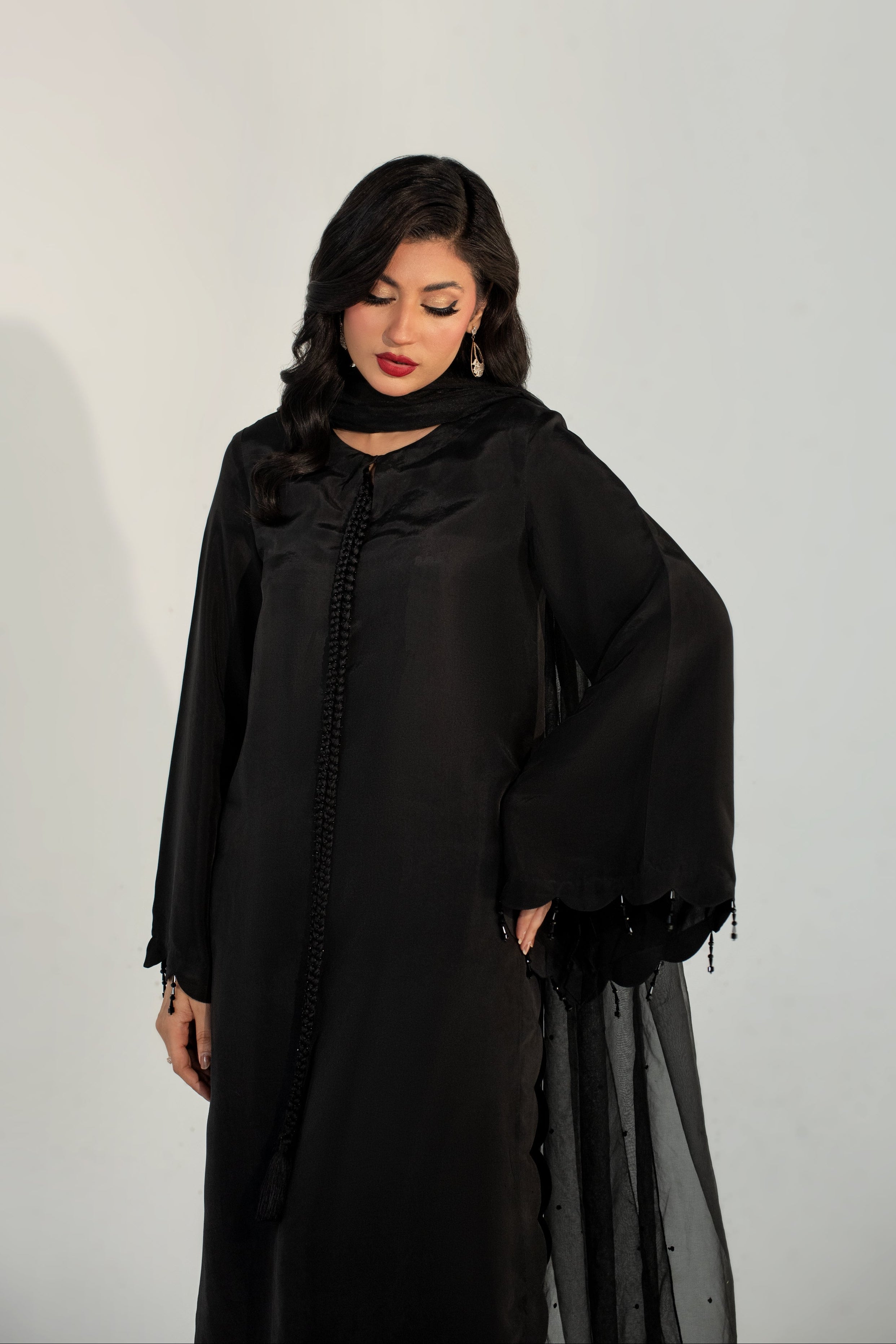 Woman wearing a black abaya against a white background