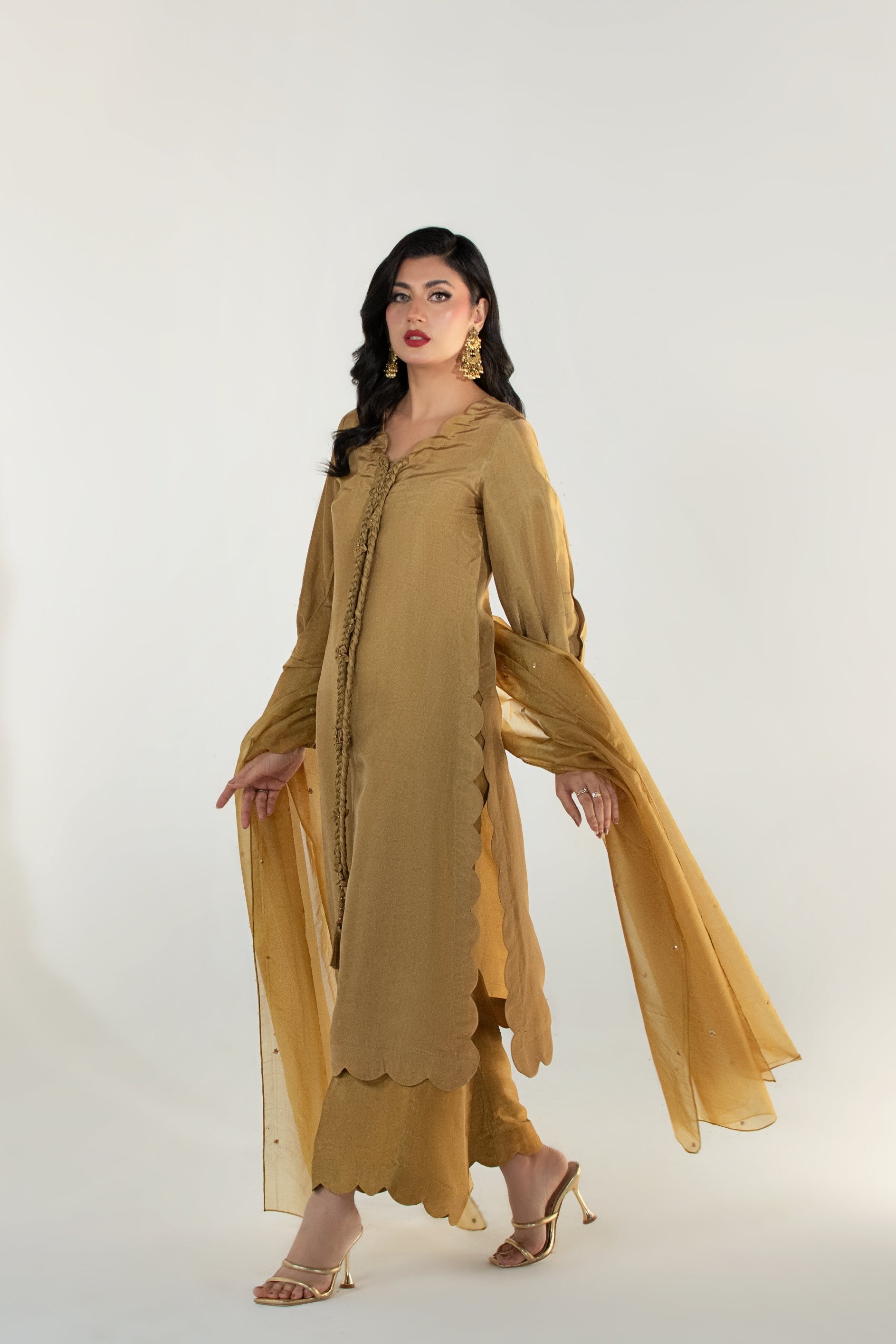 Woman wearing a mustard yellow outfit on a white background