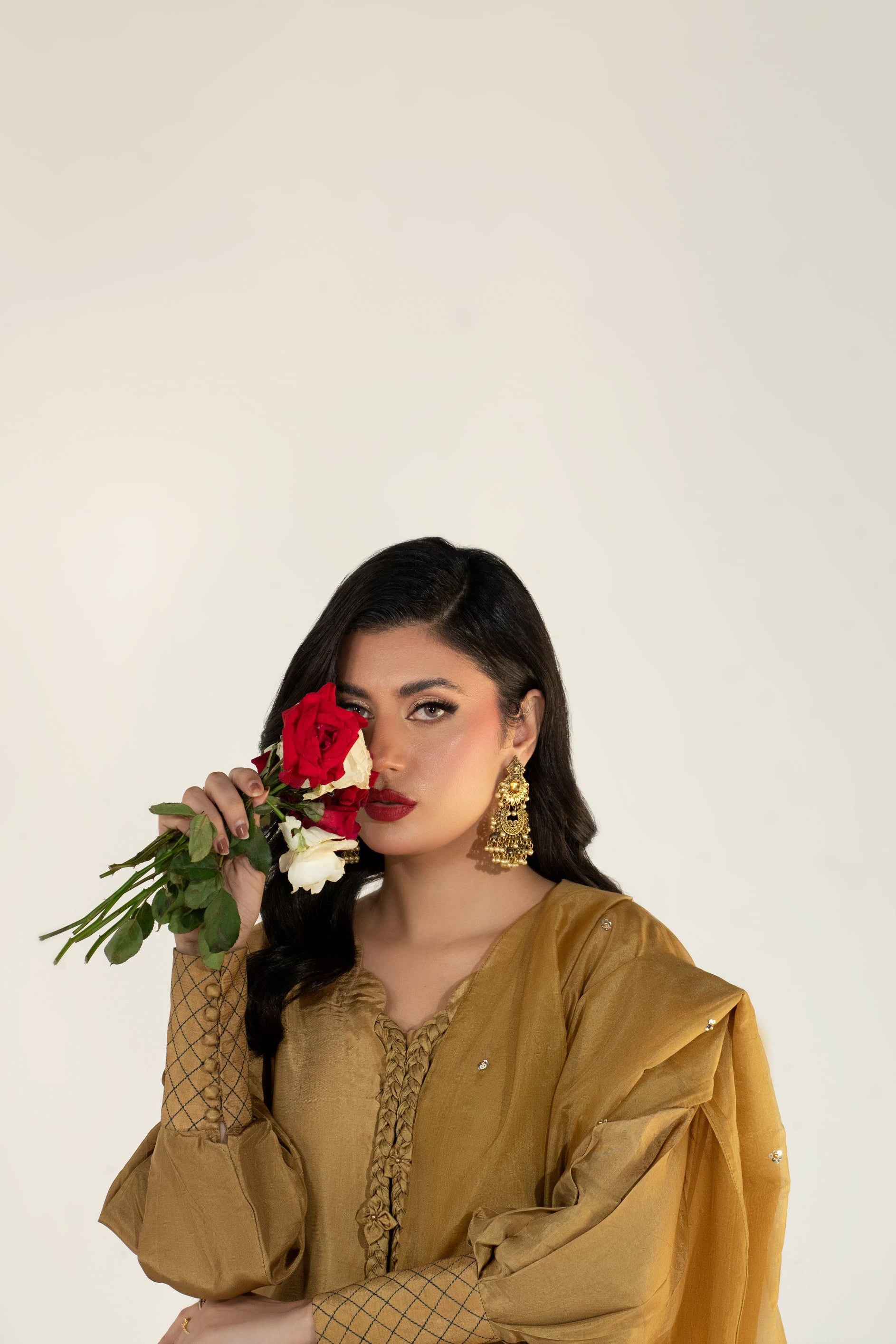 Woman holding a bouquet of flowers against a plain background