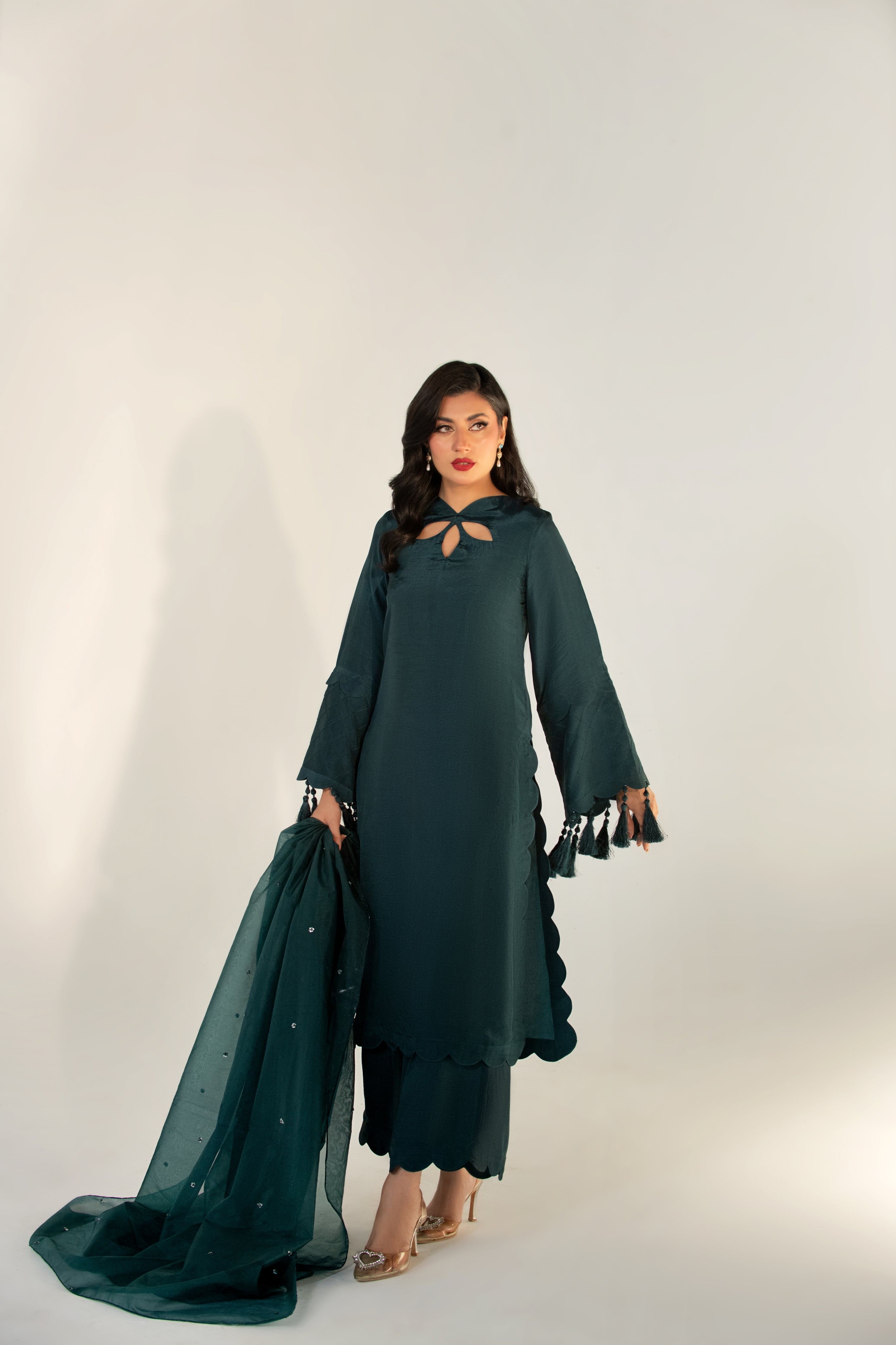 Woman wearing a dark green traditional outfit with a white background